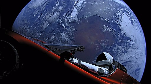 Tesla roadster with space suited mannequin and earth in the background